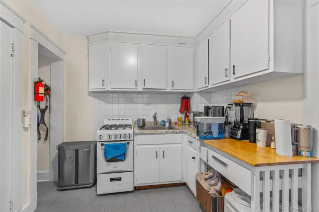 a kitchen with stainless steel appliances granite countertop a stove and white cabinets