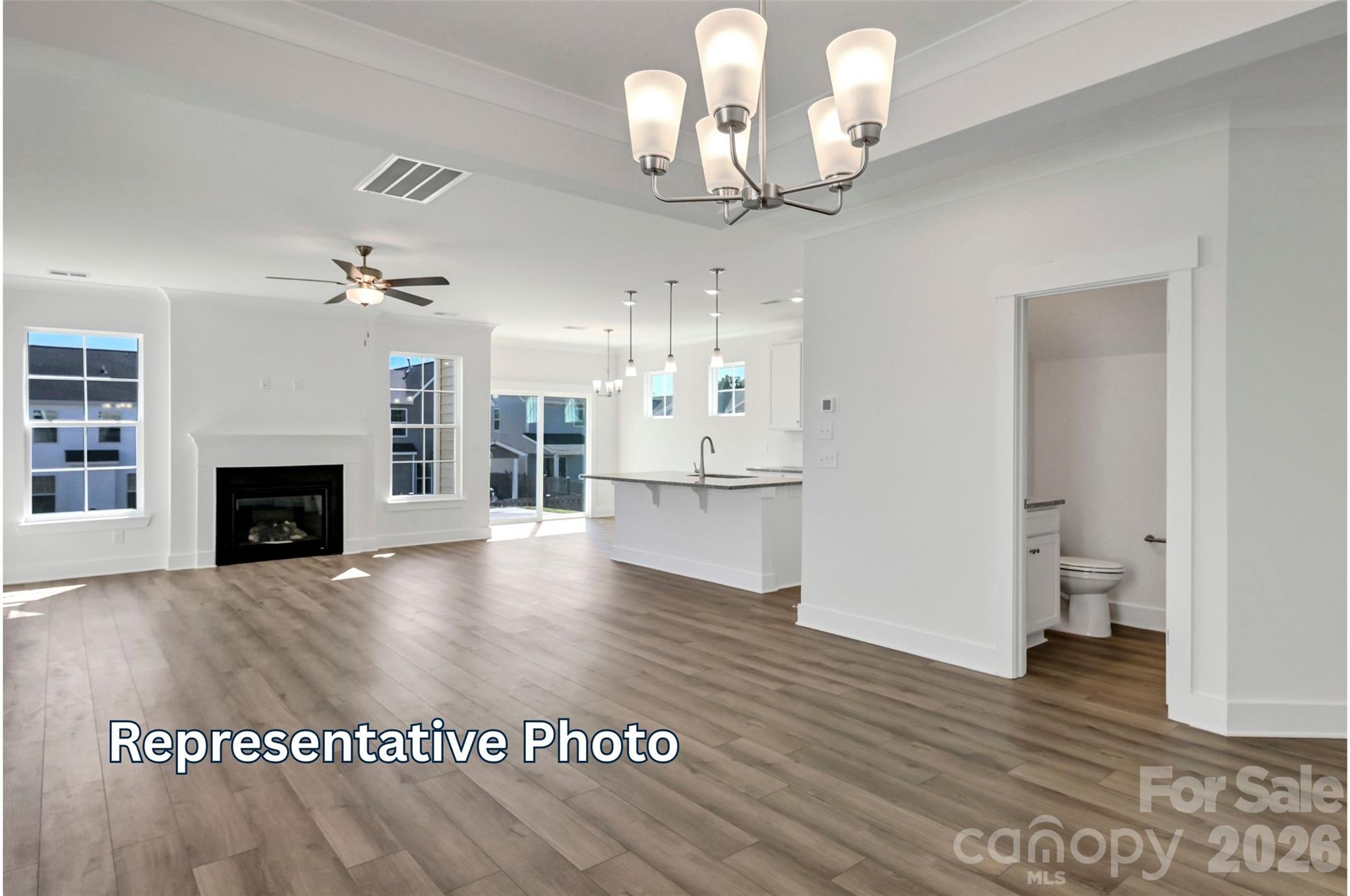 13115 Foxberry Road Charlotte, NC 28213 - Photo 4 of 20 a view of a livingroom with a fireplace a chandelier and wooden floor