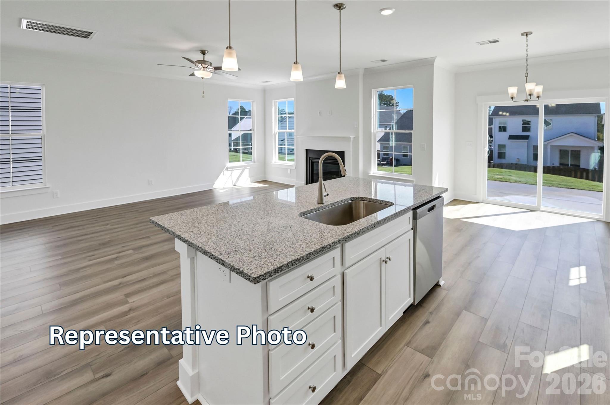 13115 Foxberry Road Charlotte, NC 28213 - Photo 6 of 20 a kitchen with stainless steel appliances granite countertop a sink a oven a dining table and chairs with wooden floor