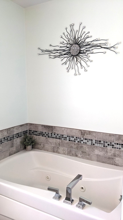 53 Baldwin Road, Unit 201 Billerica, MA 01821 - Photo 18 of 35 a bathroom with a bathtub and a window