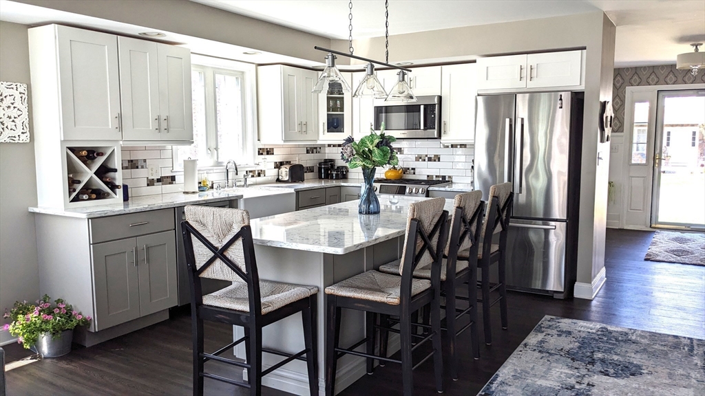 53 Baldwin Road, Unit 201 Billerica, MA 01821 - Photo 4 of 35 a kitchen with stainless steel appliances a white table chairs and a refrigerator