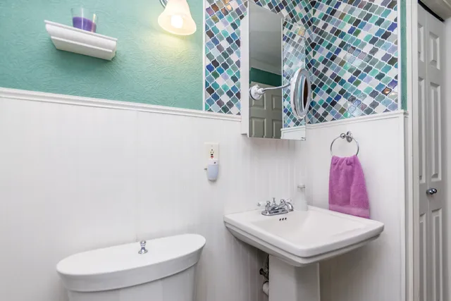 a bathroom with a sink and mirror with toilet