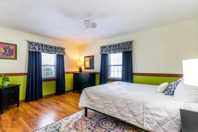 a bedroom with a bed and a dresser next to a window