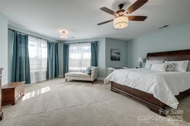 a spacious bedroom with a bed and a large window