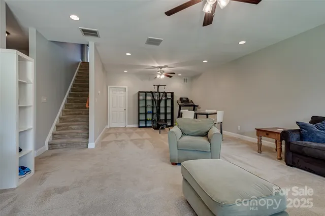 a living room with furniture and a ceiling fan