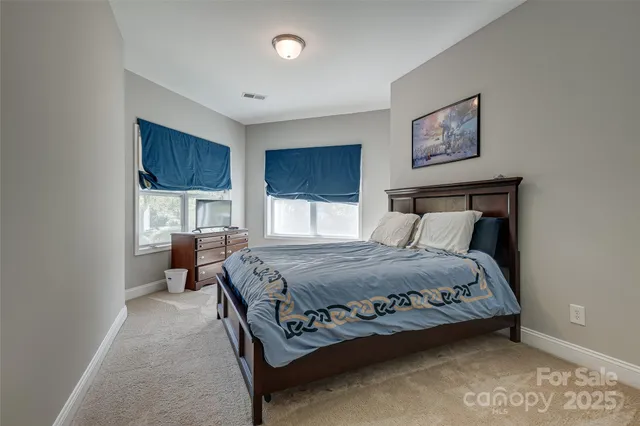 a bedroom with a bed mirror and window