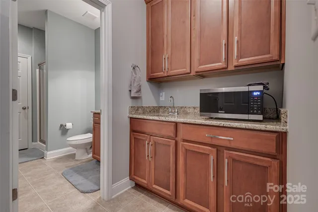 a bathroom with a granite countertop sink and a toilet