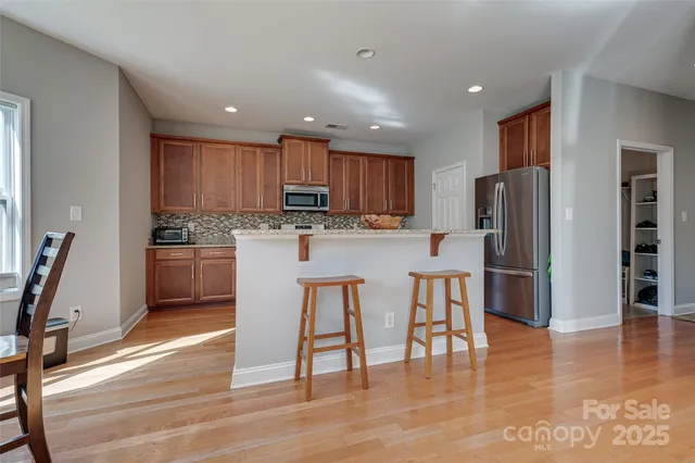 a kitchen with stainless steel appliances wooden floors and wooden cabinets