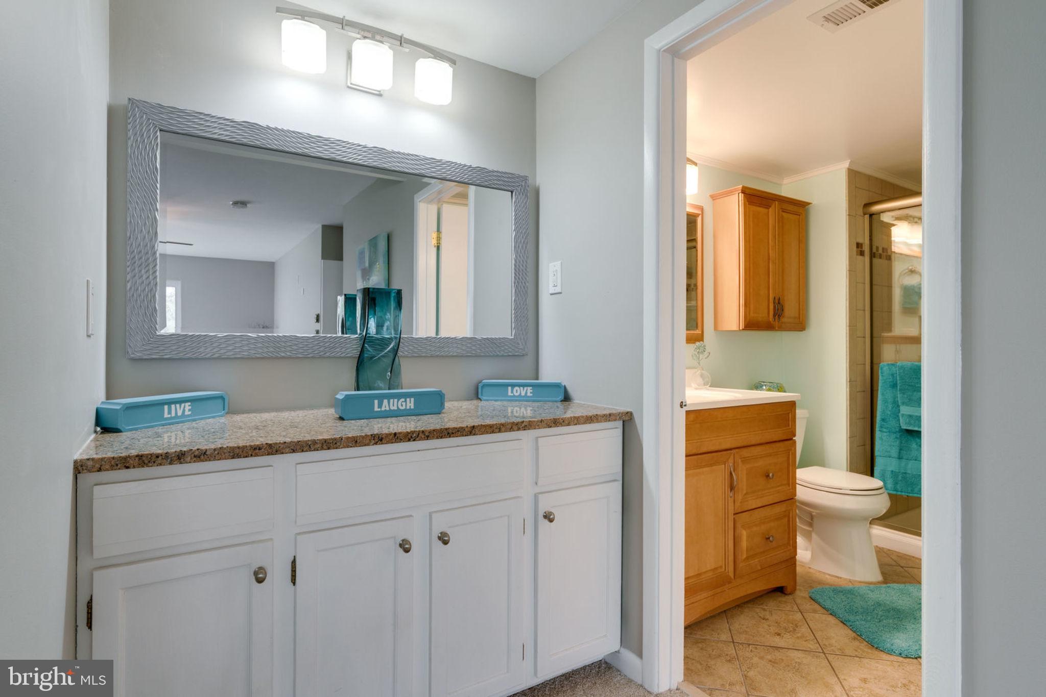 7627 Mineral Spring Court Springfield, VA 22153 - Photo 14 of 34 a bathroom with a granite countertop sink mirror vanity and toilet