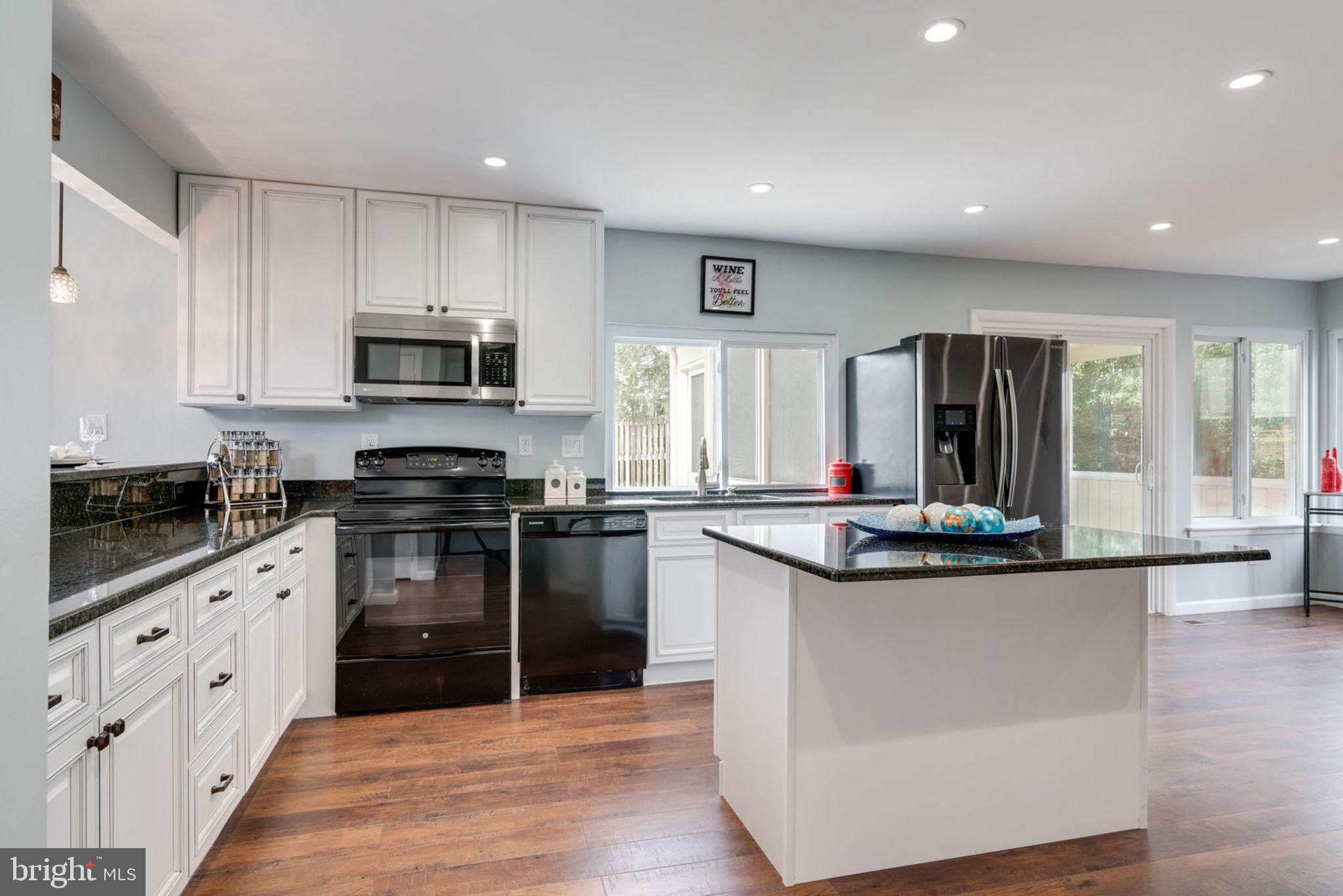 7627 Mineral Spring Court Springfield, VA 22153 - Photo 23 of 34 a kitchen with stainless steel appliances kitchen island granite countertop a stove and a sink