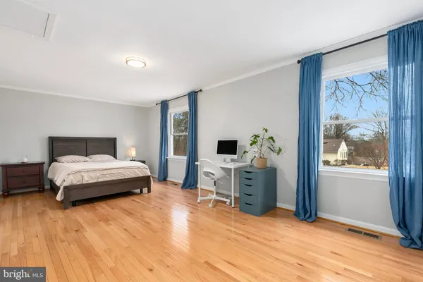 a spacious bedroom with a bed and a flat screen tv