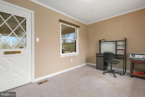 a view of a workspace with furniture and a window