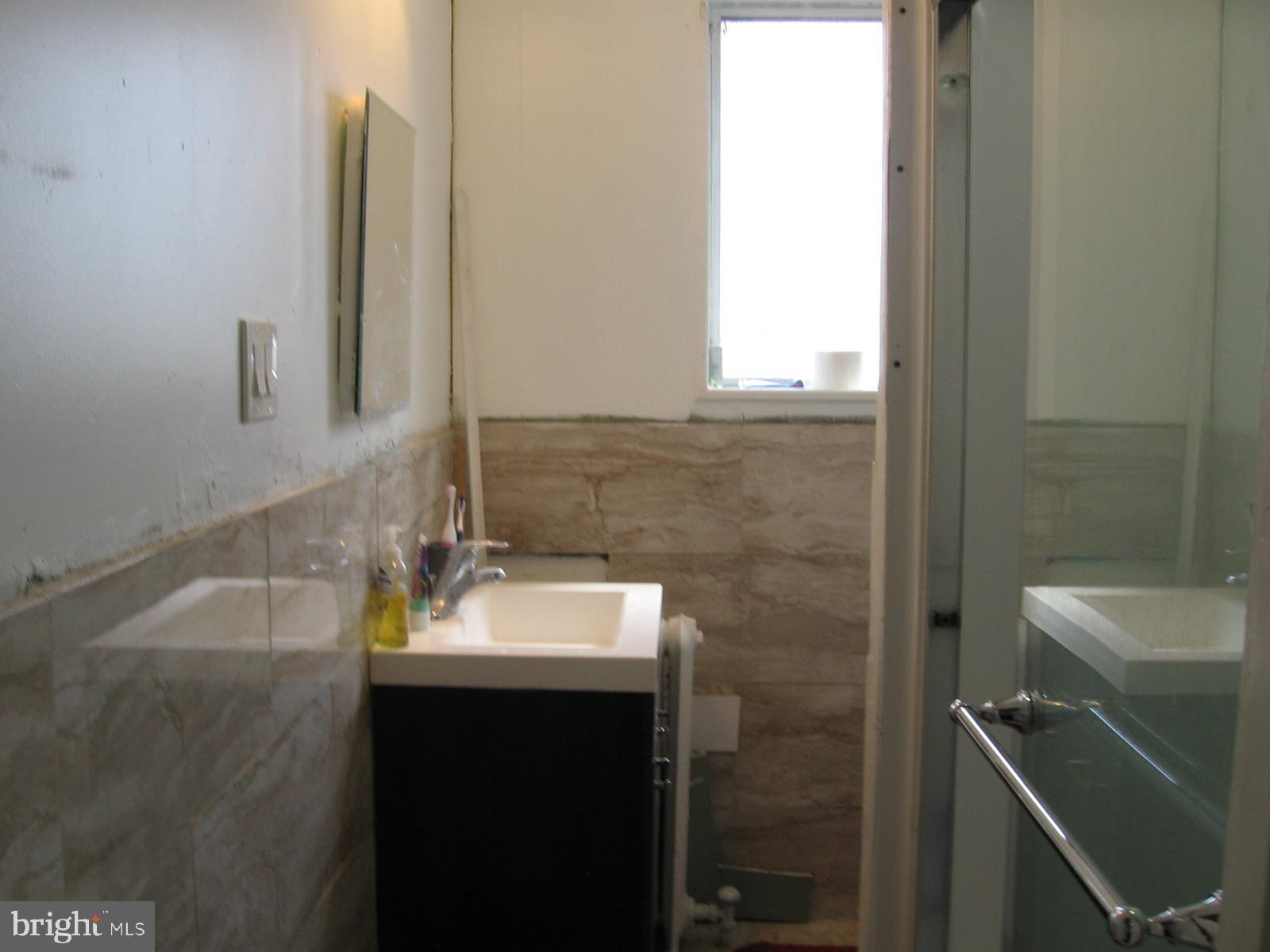 177 Wellington Road Upper Darby, PA 19082 - Photo 14 of 20 a bathroom with a sink and a mirror