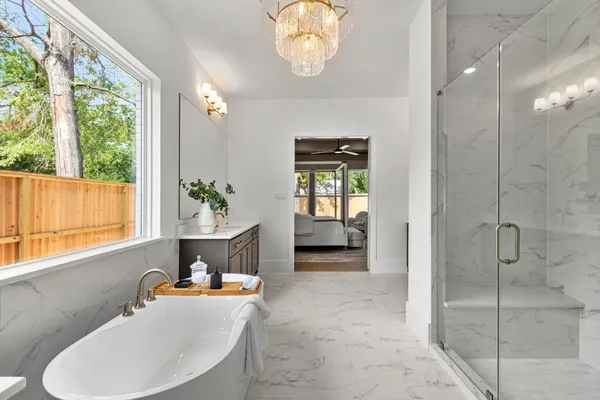 a spacious bathroom with a sink double vanity mirror and a bathtub