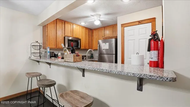 a kitchen with stainless steel appliances granite countertop a sink a stove and a refrigerator