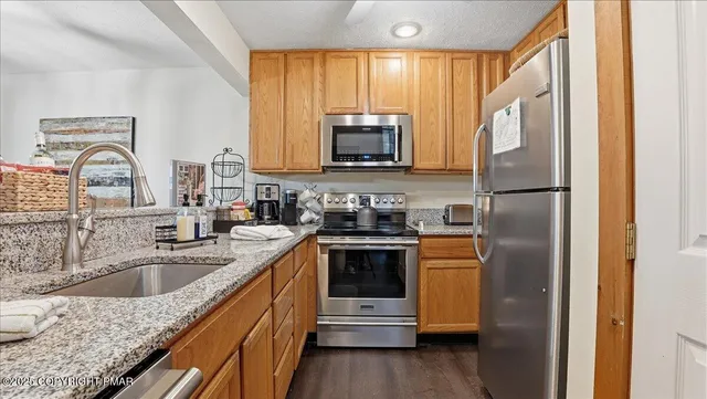 a kitchen with stainless steel appliances granite countertop a refrigerator stove and sink