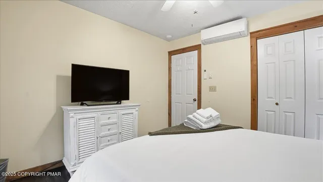 a bedroom with a bed and a flat screen tv