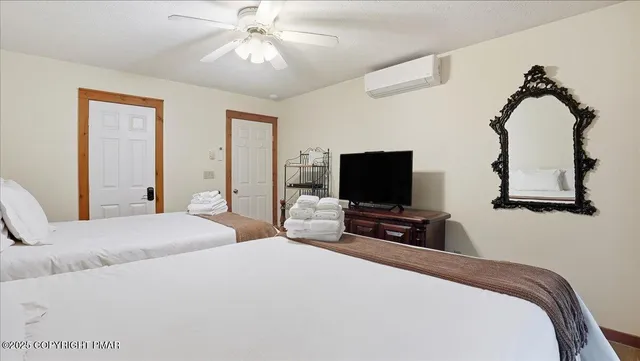 a bedroom with bed and a flat tv screen on the dresser