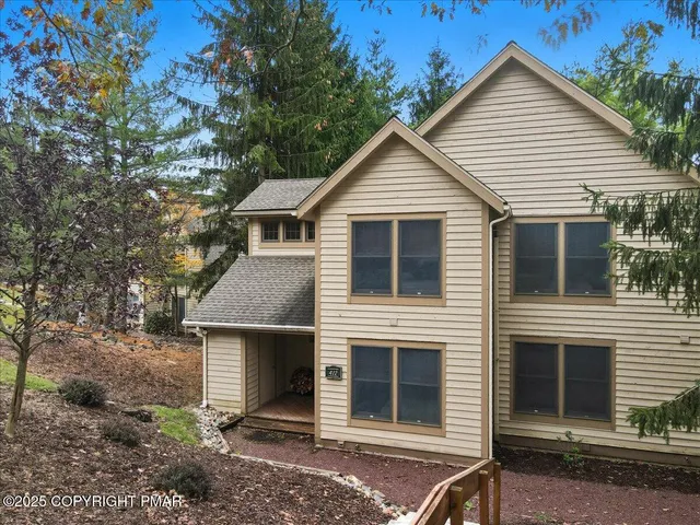 a view of a house with a yard and large tree