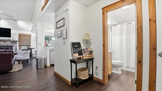 a view of a hallway with bathroom and wooden floor