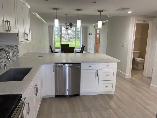 a kitchen with stainless steel appliances kitchen island wooden floors cabinets and stove