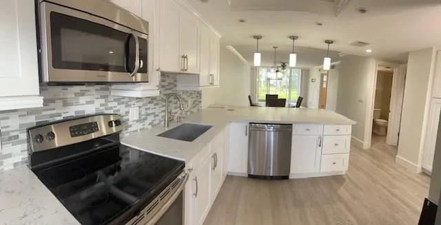 a kitchen with stainless steel appliances white cabinets and stove