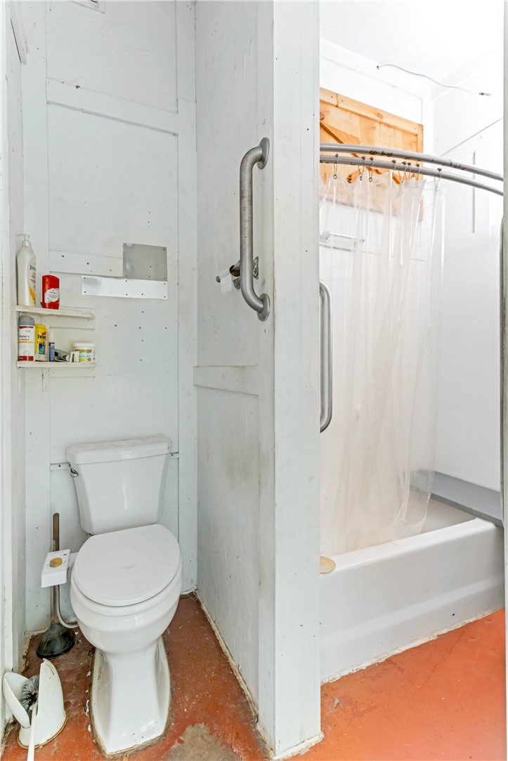2312 Old Pendleton Road Easley, SC 29642 - Photo 14 of 16 This bathroom features grab bars, a toilet, and a shower with a tub, providing accessibility and functionality.