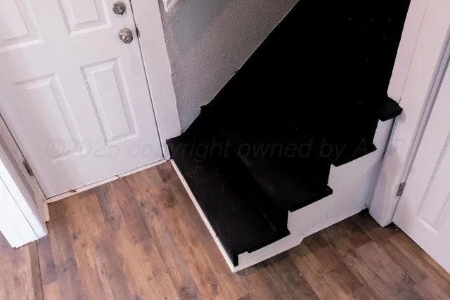 a view of a closet with wooden floor