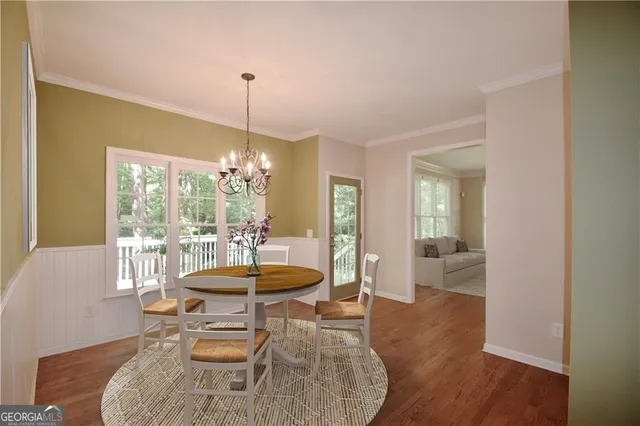 a dining room with furniture a chandelier and wooden floor