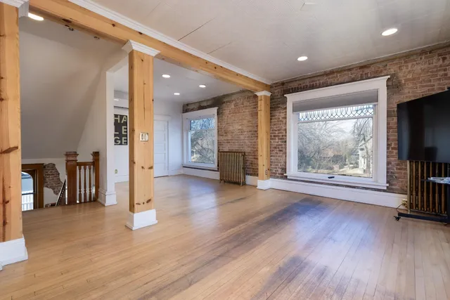 a view of a hallway with wooden floor and a fireplace