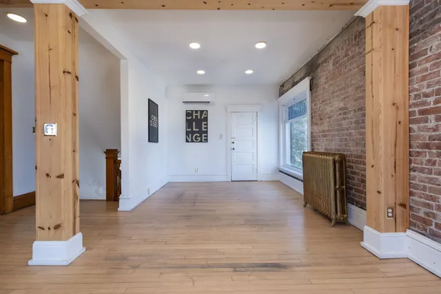 a view of a hallway with wooden floor and staircase