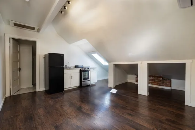 a view of empty room with wooden floor