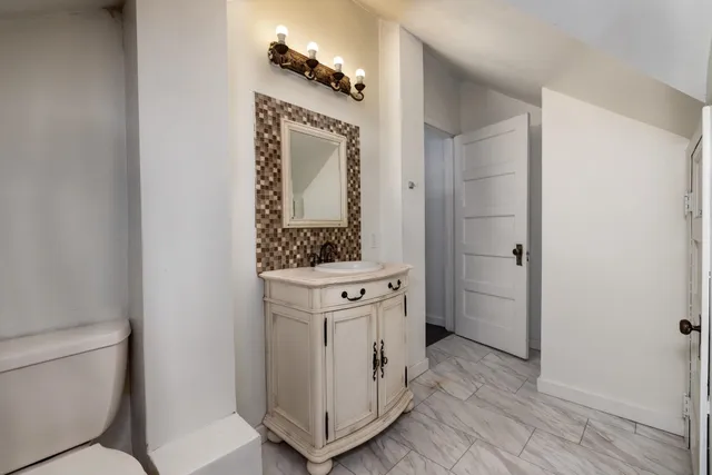 a bathroom with a toilet sink and mirror