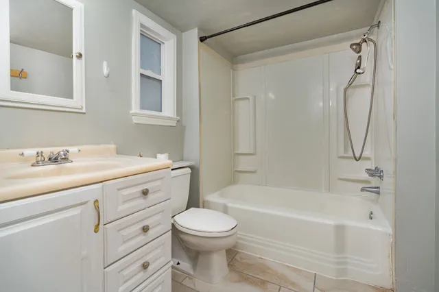 a bathroom with a granite countertop sink a toilet and a bathtub