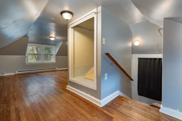 a view of a hallway with wooden floor and stairs