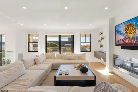 a living room with furniture kitchen view and a flat screen tv