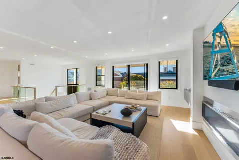 a large white kitchen with granite countertop a stove a sink a dining table and chairs