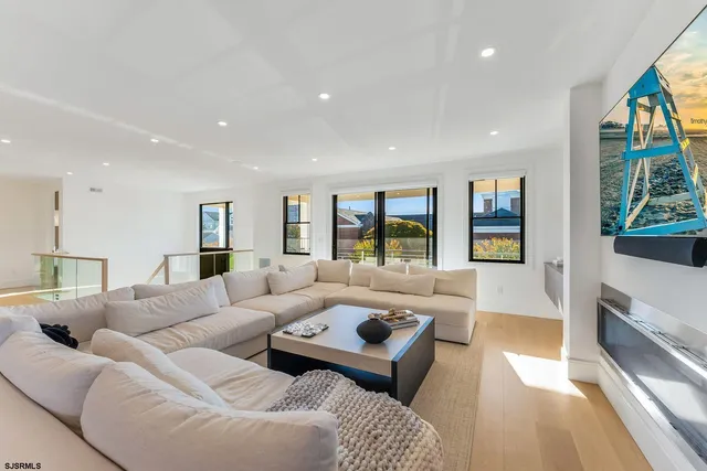 a large white kitchen with granite countertop a stove a sink a dining table and chairs