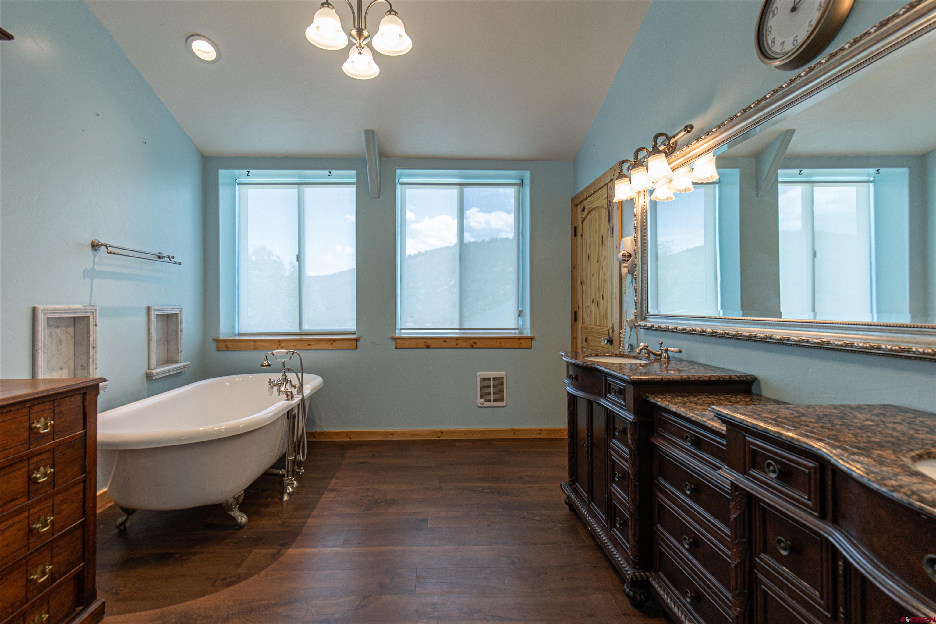 7049 County Road 105 Hesperus, CO 81326 - Photo 15 of 23 a bathroom with a double vanity sink a mirror and a bathtub