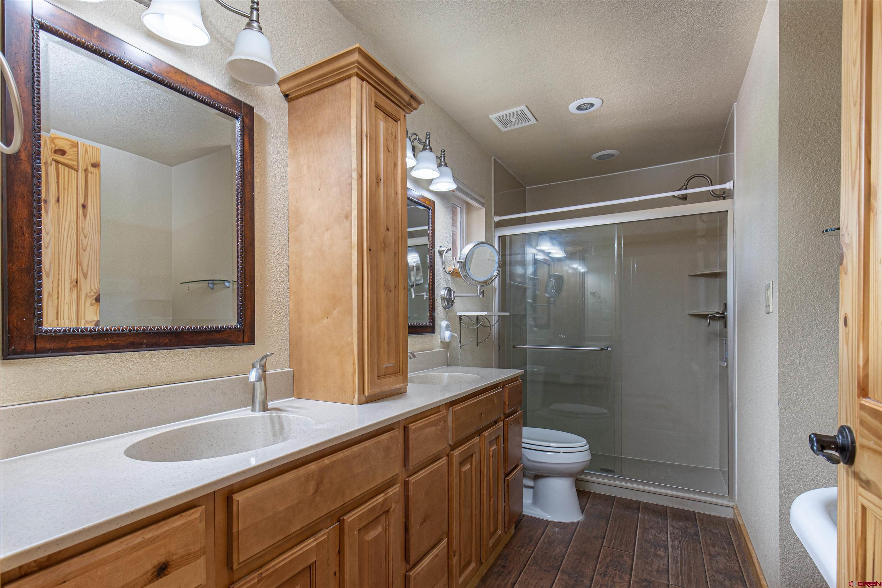 7049 County Road 105 Hesperus, CO 81326 - Photo 21 of 23 a bathroom with a granite countertop sink toilet a mirror a vanity and shower