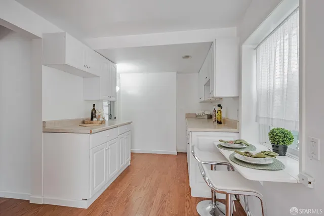 a kitchen with stainless steel appliances a table and chairs in it