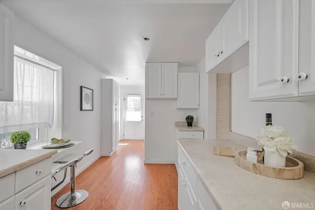 a kitchen with granite countertop a sink cabinets and wooden floor