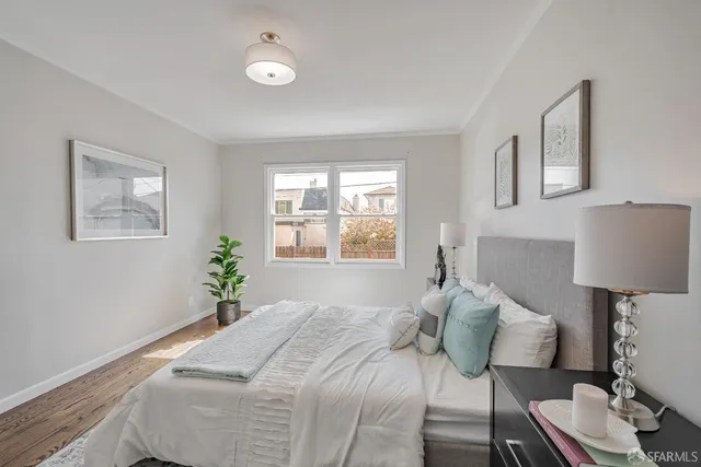 a bedroom with a bed and painting on the wall
