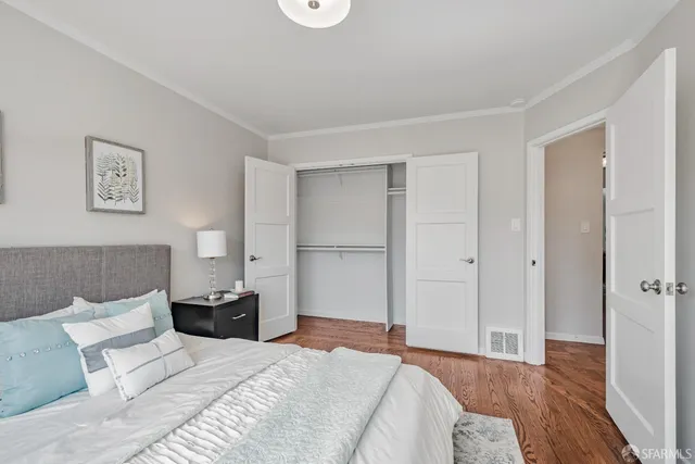 a bedroom with a bed and a painting on the wall