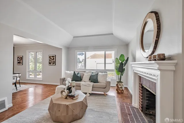 a living room with furniture a fireplace and a potted plant