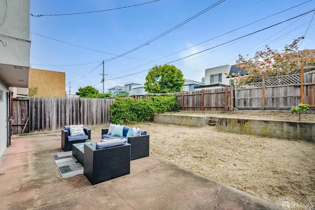 a view of a patio with couches chairs and wooden floor