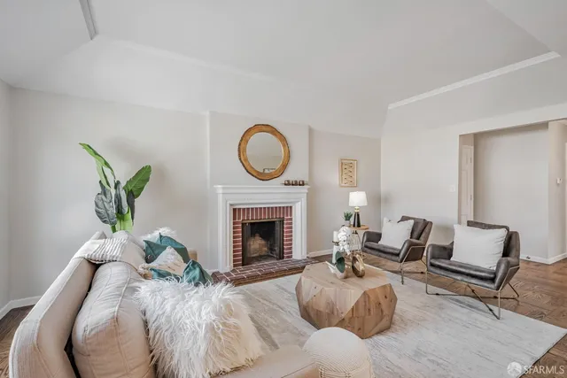 a living room with furniture a fireplace and a potted plant