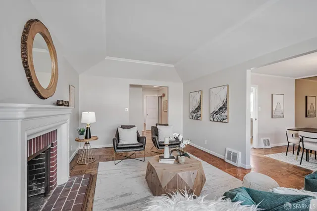 a living room with furniture a fireplace and wooden floor