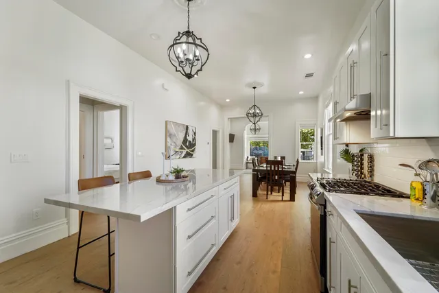 a bedroom with a bed chandelier and a window