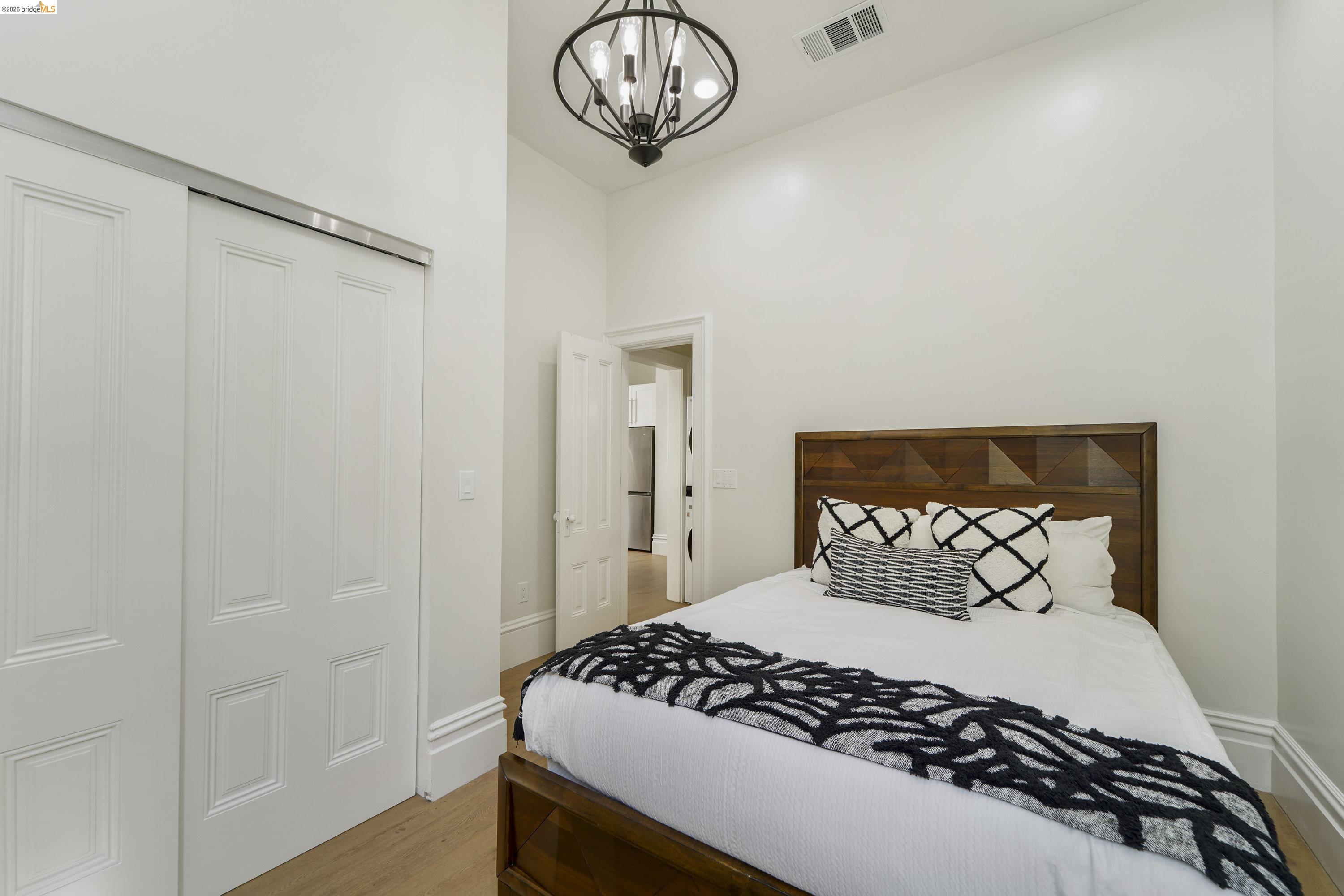 1662 14th Street Oakland, CA 94607 - Photo 32 of 57 a bedroom with a bed and a chandelier